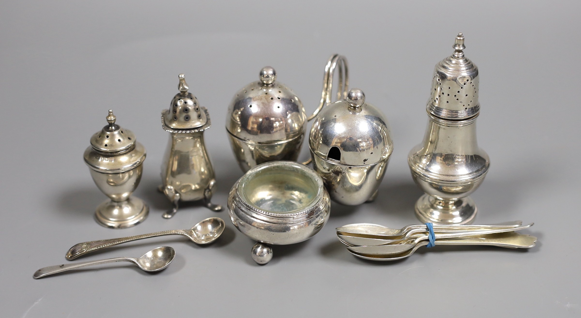 An Edwardian silver cruet stand, by Goldsmiths & Silversmiths, London, 1901, four other silver condiments and a set of six silver coffee spoons.